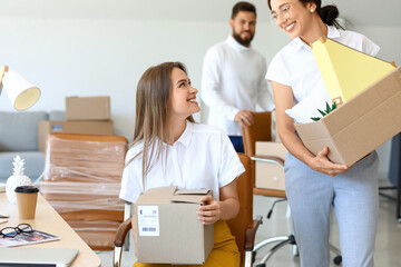 Female colleagues packing things in office on moving day