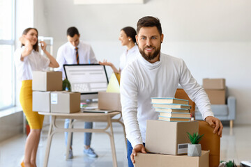 Handsome man near chair with boxes in office on moving day