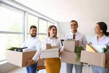 Fototapeta na wymiar Business people holding boxes with things in office on moving day