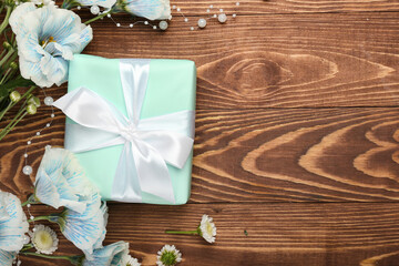 Gift box with flowers and beads on dark wooden background