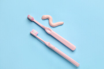 Sample of toothpaste and brushes on blue background