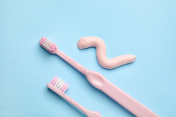 Sample of toothpaste and brushes on blue background, closeup