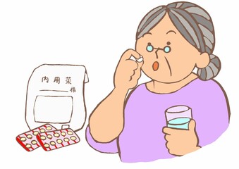 認知症進行抑制剤をコップの水で内服する軽度認知症の高齢女性