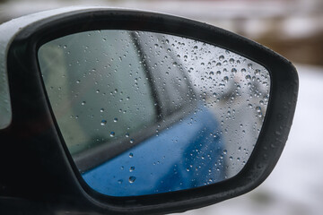 Side mirror of car, driving during rainy day