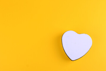 White Canister with Heart Shape on Yellow Background. COpy Space for Text, Valentine Concept