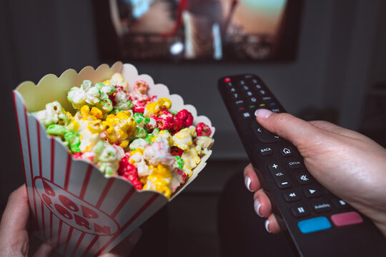 Woman Watching TV Or Watching Movie With Remote Control And Popcorn At Home. First Person View