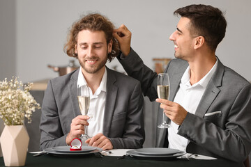 Young gay proposing to his boyfriend on romantic date