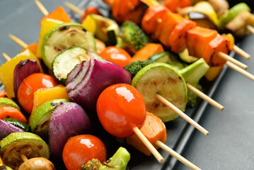 Plate with tasty vegetable skewers on table, closeup