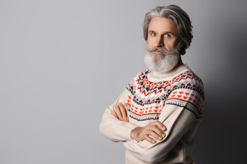 Fototapeta premium Handsome senior man in knitted sweater on grey background