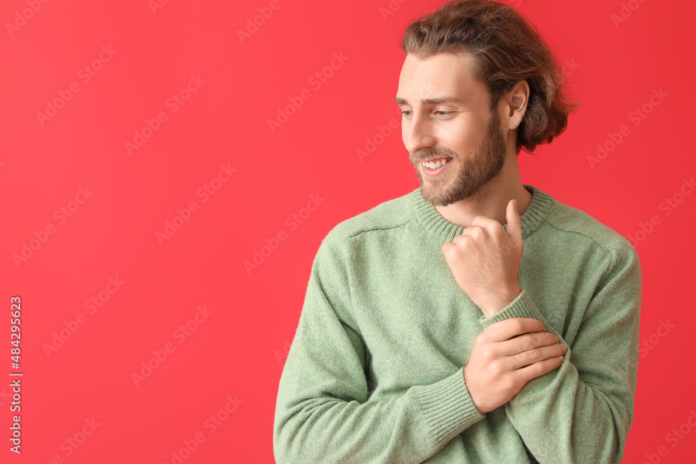 Poster Handsome young man in knitted sweater on color background