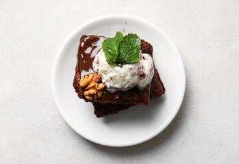 Plate with pieces of tasty chocolate brownie on white background