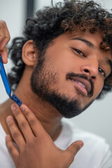 Focused male using a safety razor for neck hair removal