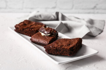 Plate with pieces of tasty chocolate brownie on table