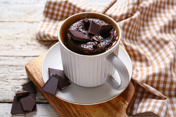 Cup with tasty chocolate brownie on white wooden background