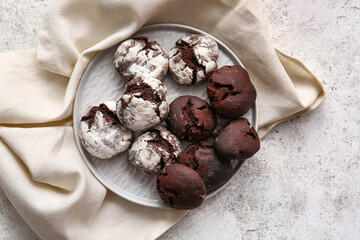 Plate with tasty brownie cookies on light grunge background