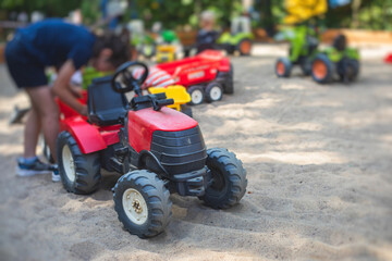 Children playing in the sandbox sandpit, kids with toy car vehicle, playground in kindergarten day care