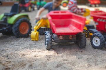 Children playing in the sandbox sandpit, kids with toy car vehicle, playground in kindergarten day care