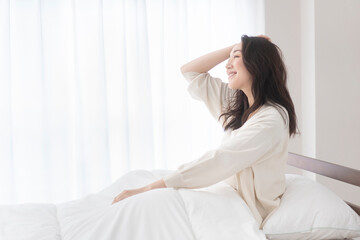 朝、ベッドでリラックスしている女性