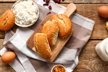 Board of tasty sochniki with cottage cheese on wooden background