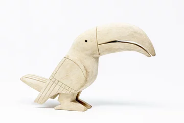 Zelfklevend Fotobehang Wooden statue of toucan bird handcrafted on white background © PhotoSpirit