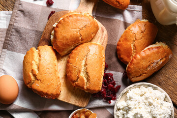 Wooden board of tasty sochniki with cottage cheese on table