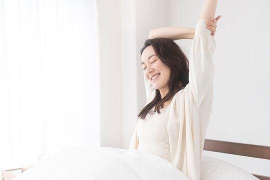 朝、ベッドでリラックスしている女性
