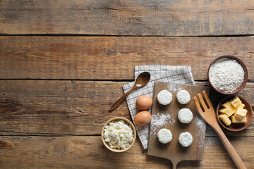 Board with uncooked cottage cheese pancakes and ingredients on wooden background - obrazy, fototapety, plakaty