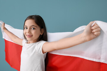 Cute little girl with flag of Poland on color background