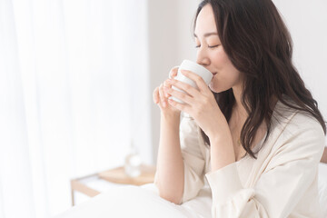 朝、温かい飲み物を飲む女性