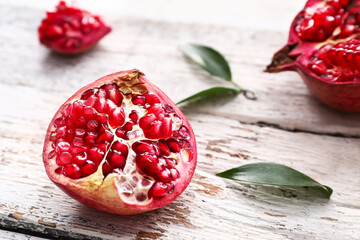 Ripe delicious pomegranate on light wooden background