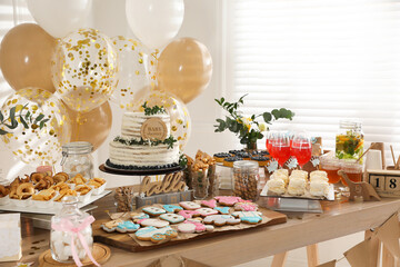 Baby shower party. Different delicious treats on wooden table and decor indoors