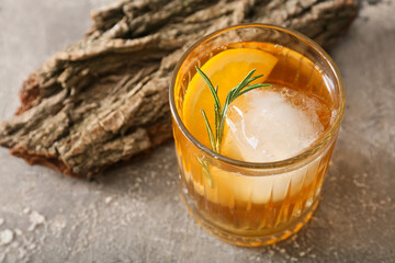 Glass of delicious Old Fashioned Cocktail on grey background