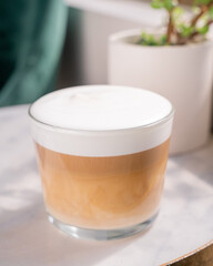 hot coffee macchiato in a clear glass cup