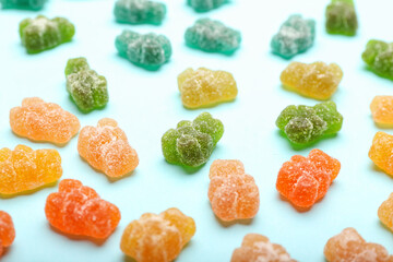 Different tasty jelly bears on color background