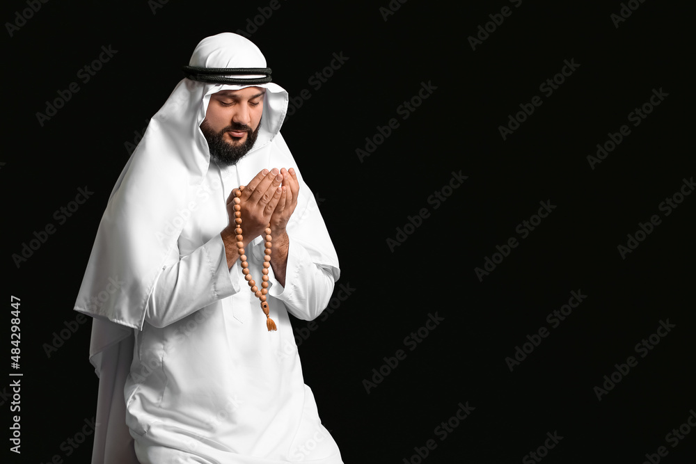 Wall mural muslim man praying on black background