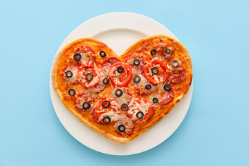 Plate with tasty heart-shaped pizza on blue background. Valentine's Day celebration