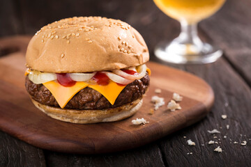 Burger with cheedar cheese, onion and ketchup.