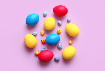 Different painted Easter eggs on color background