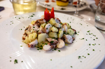 Tasty seafood salad with boiled octopus, potatoes, olive oil parsley served in Italian restaurant