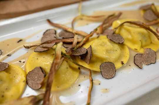 Italian food, fresh home made red potato stuffed pasta tortellacci or ravioli dumplings with summer black truffle and cripsy green asparagus, Parma, Emilia Romagna, Italy