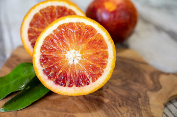 Sicilian sweet juicy yellow and red blood oranges with green leaves close up