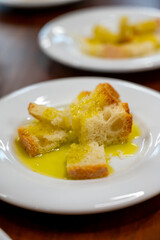 Tasting of Italian extra virgin olive oil with bread on organic farm in Tuscany, Italy