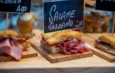 Italian street food, Parma ham sandwiches, bread with cured meats in market in Florence, Italy...