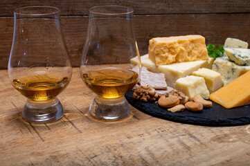 British drinks and food, glasses of Scotch whisky and cheeses collection, blue Stilton, Scottish coloured and English matured cheddar cheeses