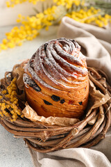 Wicker wreath with delicious Easter cake on table