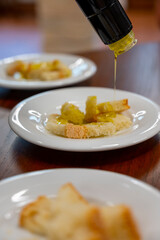 Tasting of Italian extra virgin olive oil with bread on organic farm in Tuscany, Italy