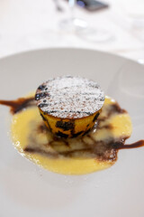 Tasty Italian dessert, small hot cake with chocolate and white gravy on white plate