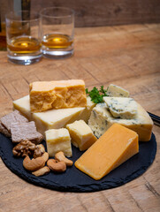 British drinks and food, glasses of Scotch whisky and cheeses collection, blue Stilton, Scottish coloured and English matured cheddar cheeses