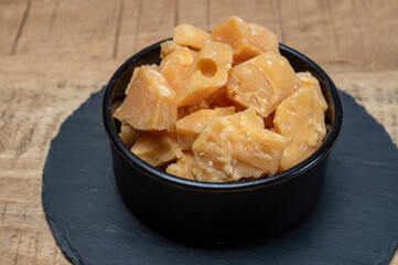 Cheese tasting, small pieces of old Dutch hard cheese and bowl with homemade dill-mustard sauce