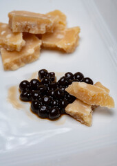 Tasting of 72 months very old Italian parmigiano-reggiano parmesan cheese from Parma  with intense taste with black pearls of balsamic vinegar DOP from Modena.